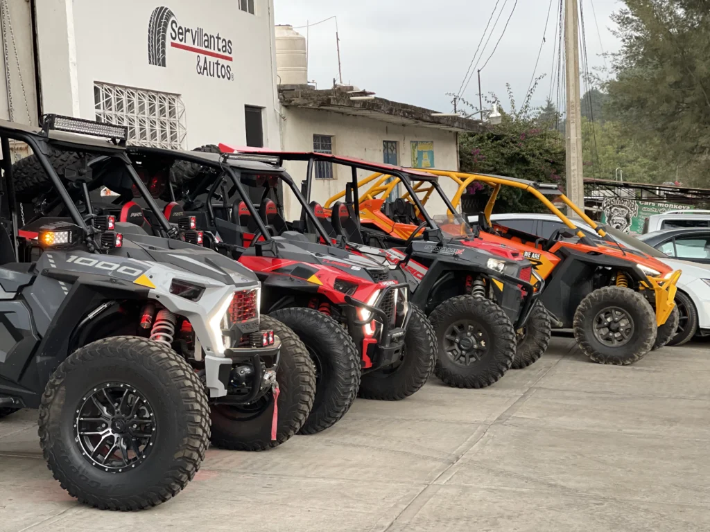 Flota de vehículos off-road preparados afuera del taller Servillantas y Autos